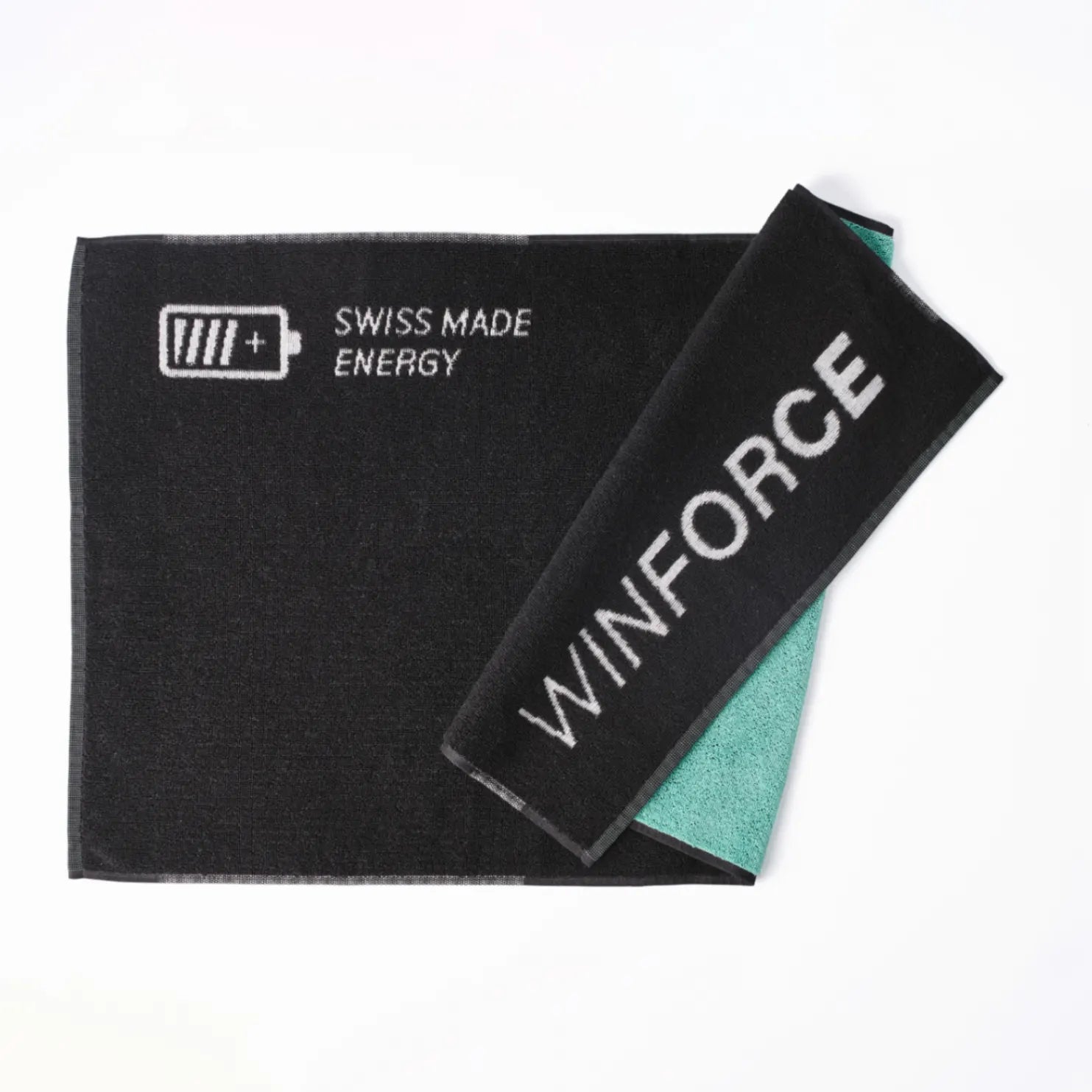Hochwertiges, schwarzes WINFORCE Sporthandtuch, teils gefaltet, mit weißem Schriftzug "SWISS MADE ENERGY" und voller Batterieanzeige. Der gefaltete Bereich zeigt den Markennamen "WINFORCE" in Weiß und die Unterseite ist in einem frischen Mintgrün gehalten.